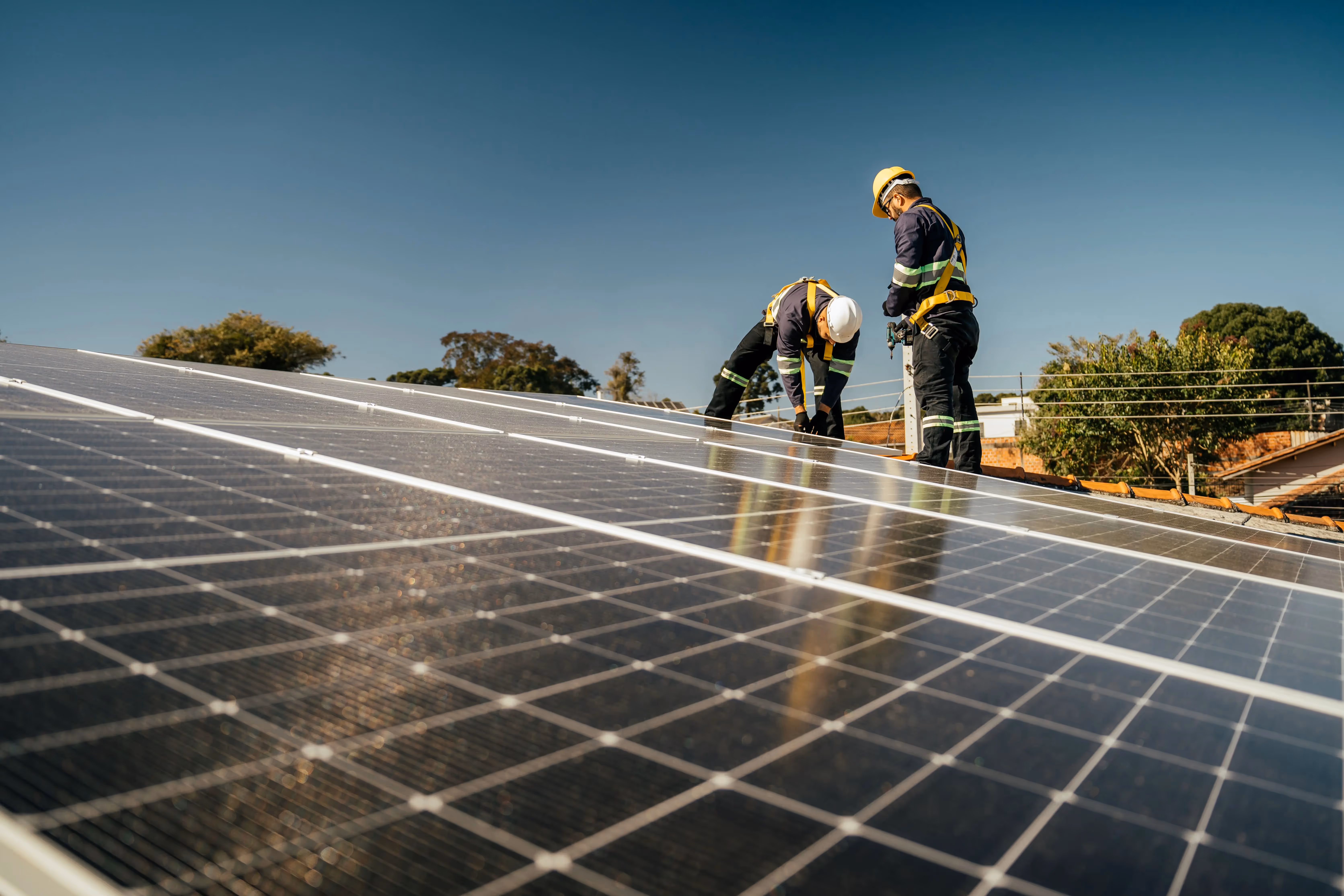 men installing solar panels on a roof