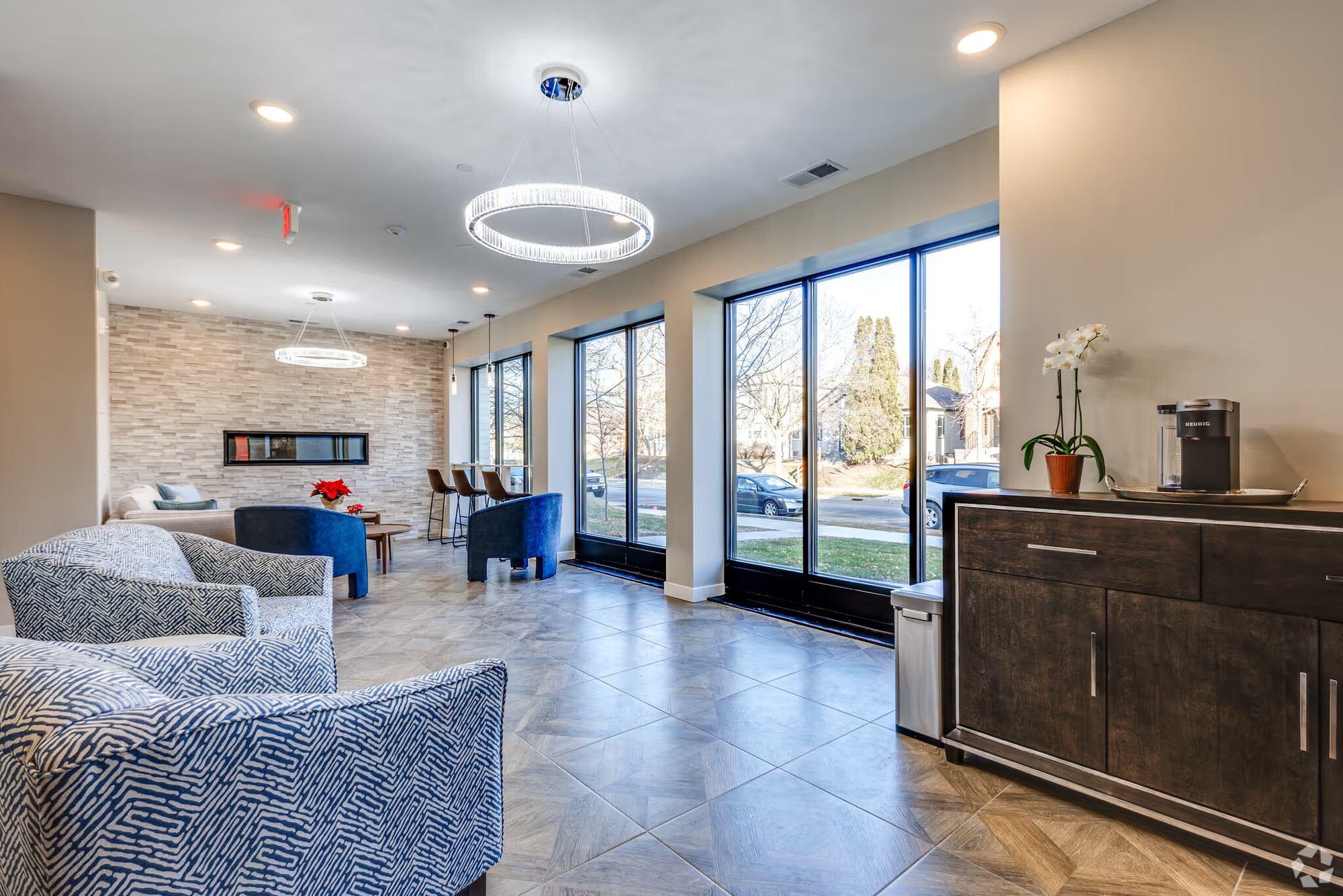 Fuller Park Flats shared lobby lounge with full-height windows, a linear fireplace and seating.