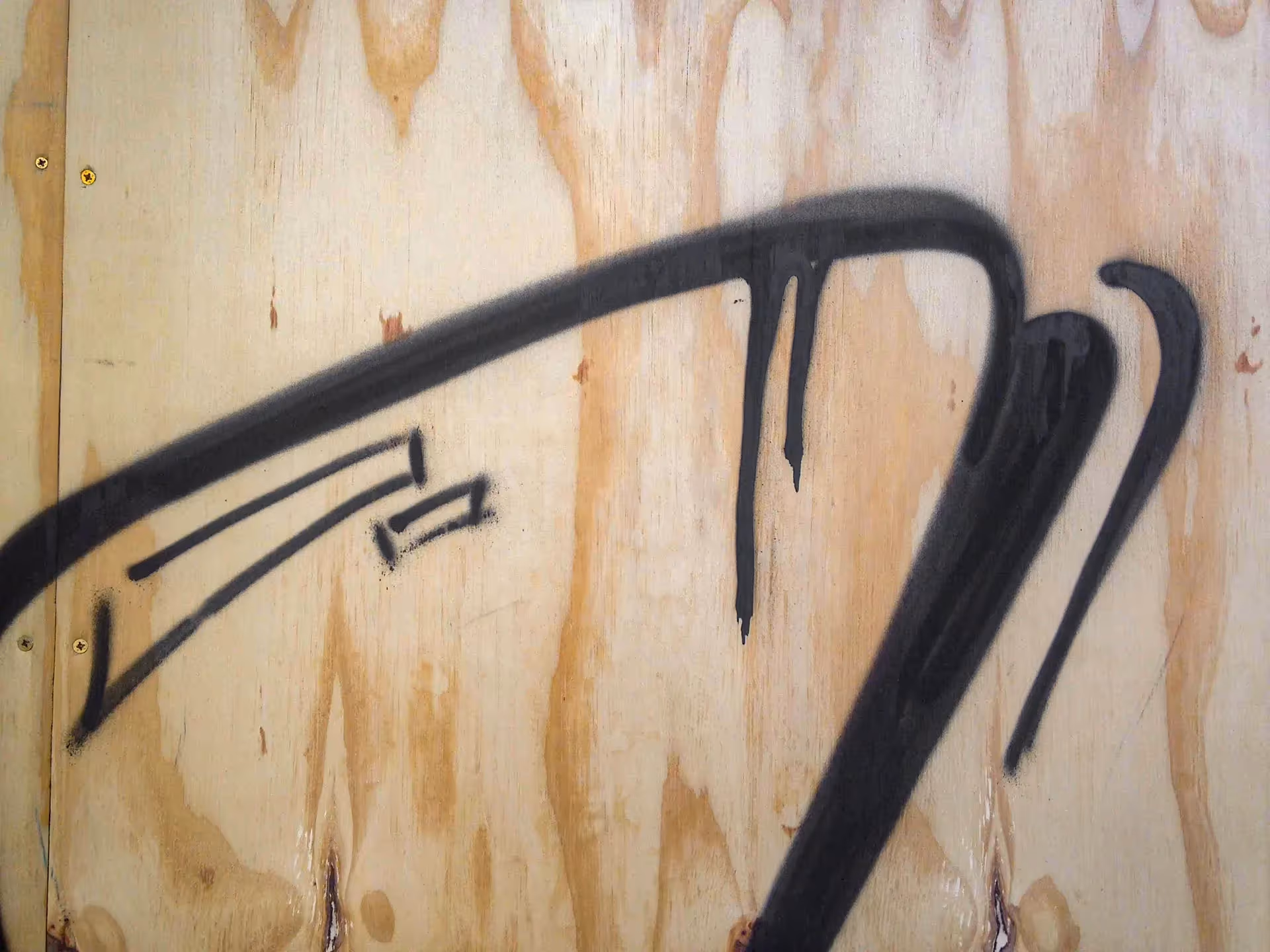 Details of an outline Kilos graffiti bombing on wood wall