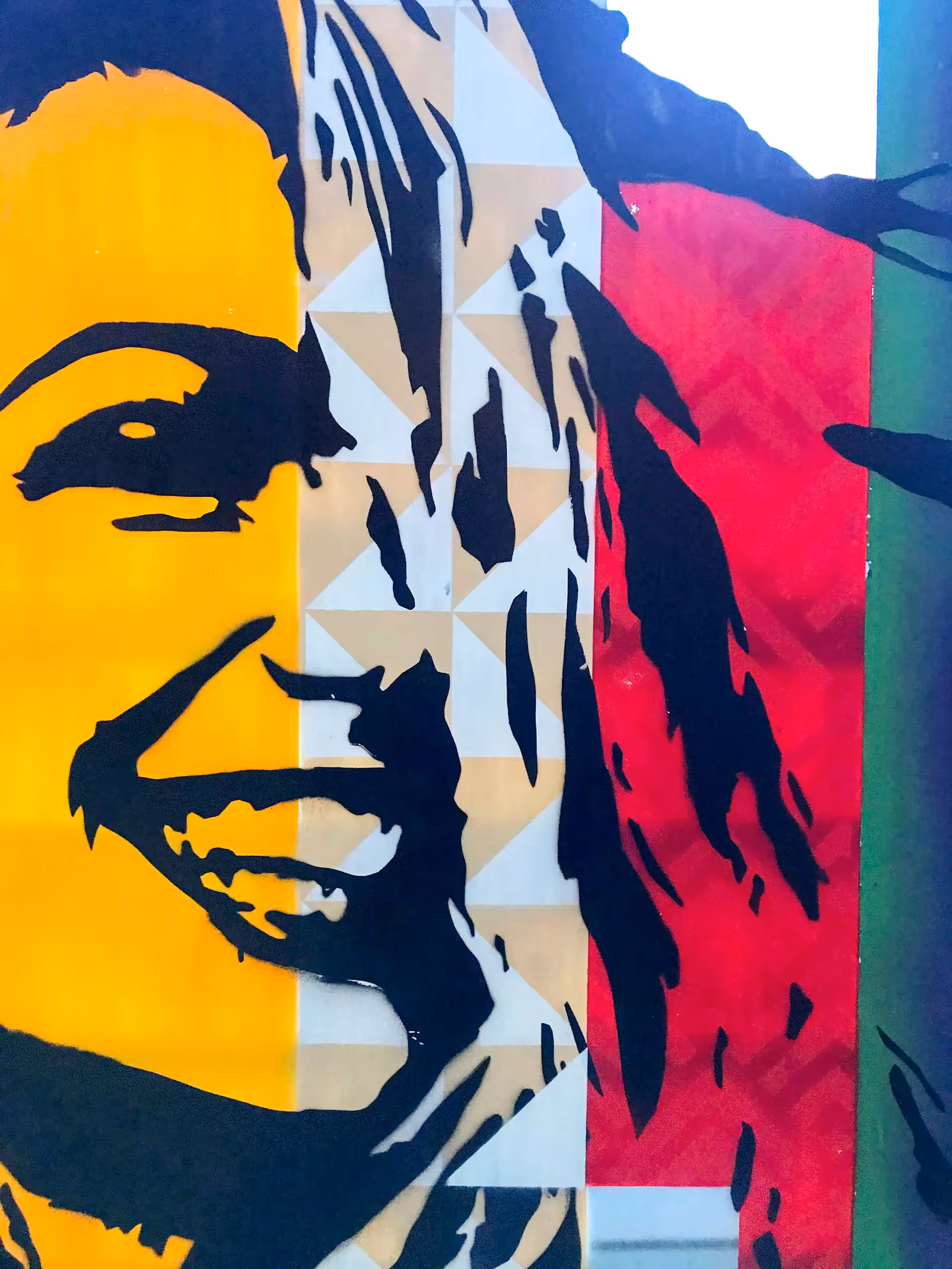 Close-up of a stencil painting of a young adult white girl on top of a colorful vertical stripes background