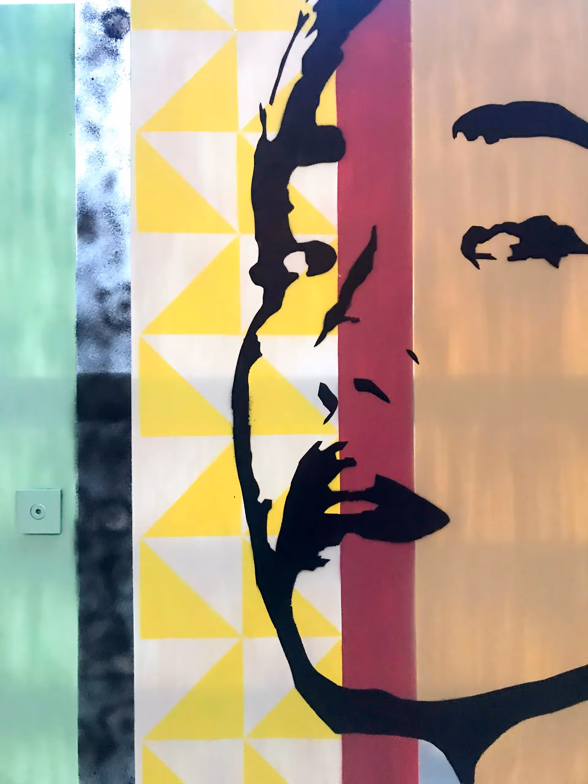 Close-up of a stencil painting of a young adult asian girl on top of a colorful vertical stripes background