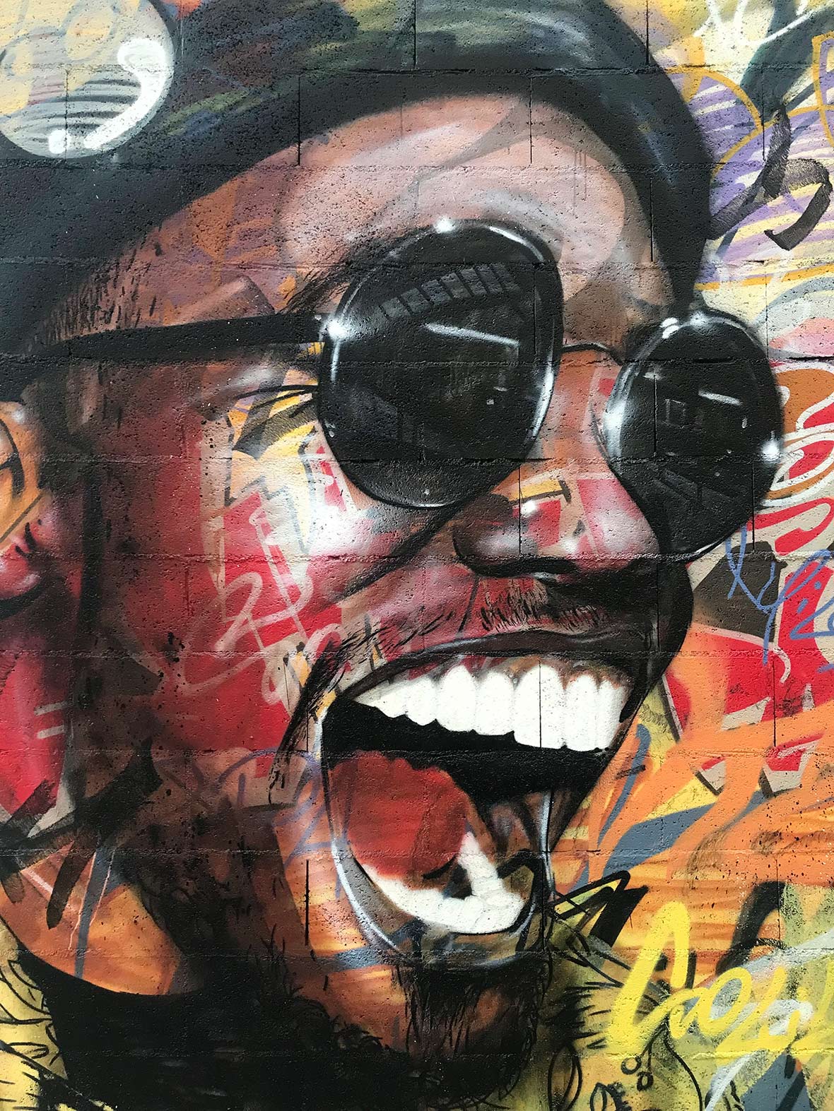Portrait of Anderson Paak over a background of graffiti letters