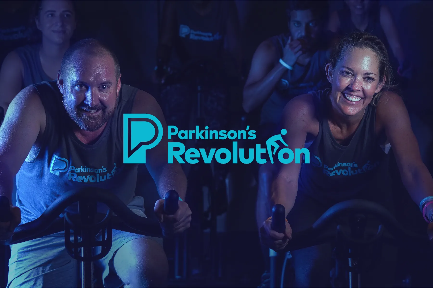 People on an indoor bicycle and the Parkinson's Revolution logo.