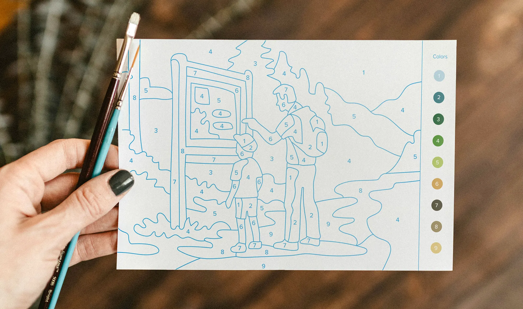 Photo os a hand holding a postcard with an illustration in a paint-by-numbers style