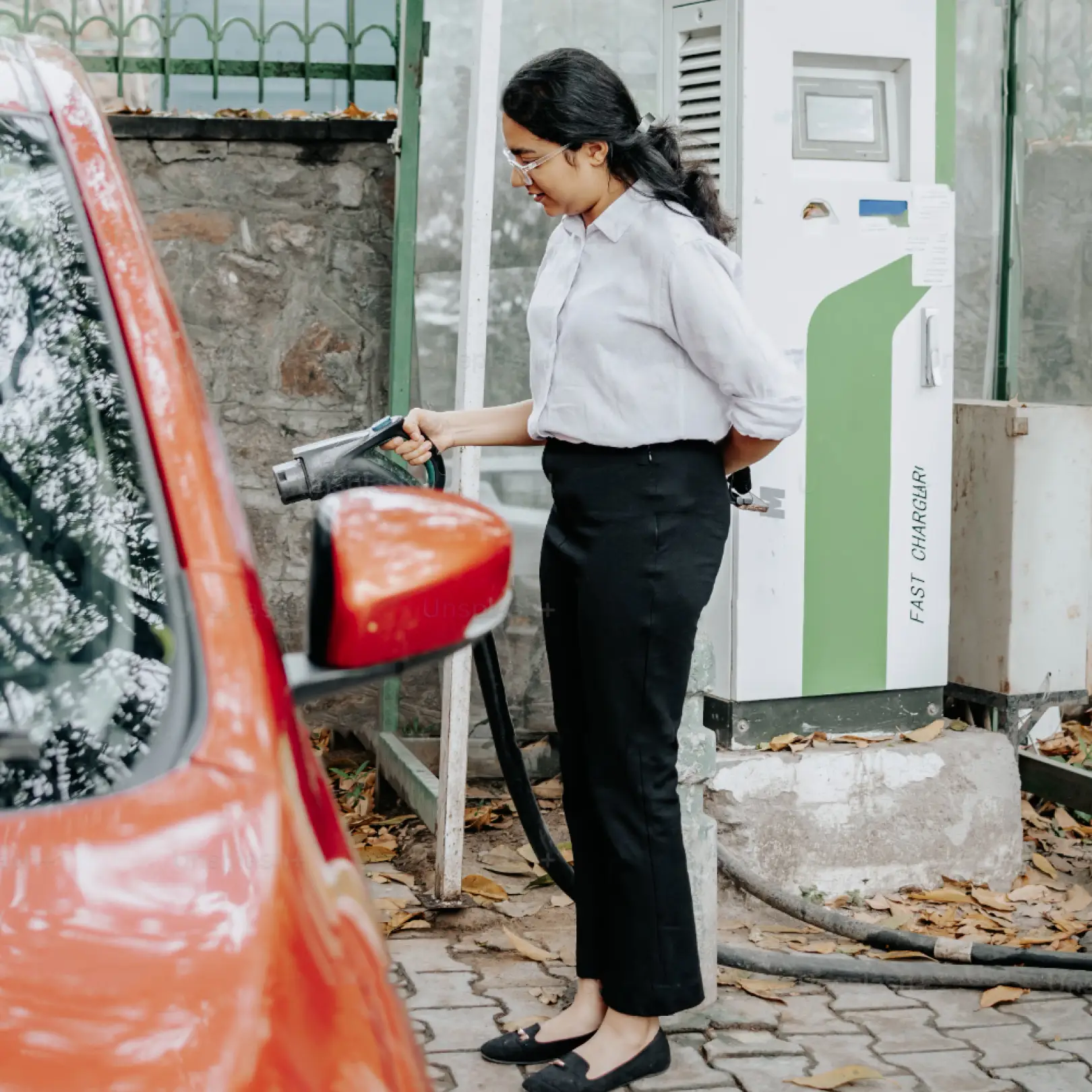 photo of a woman charging a electric car