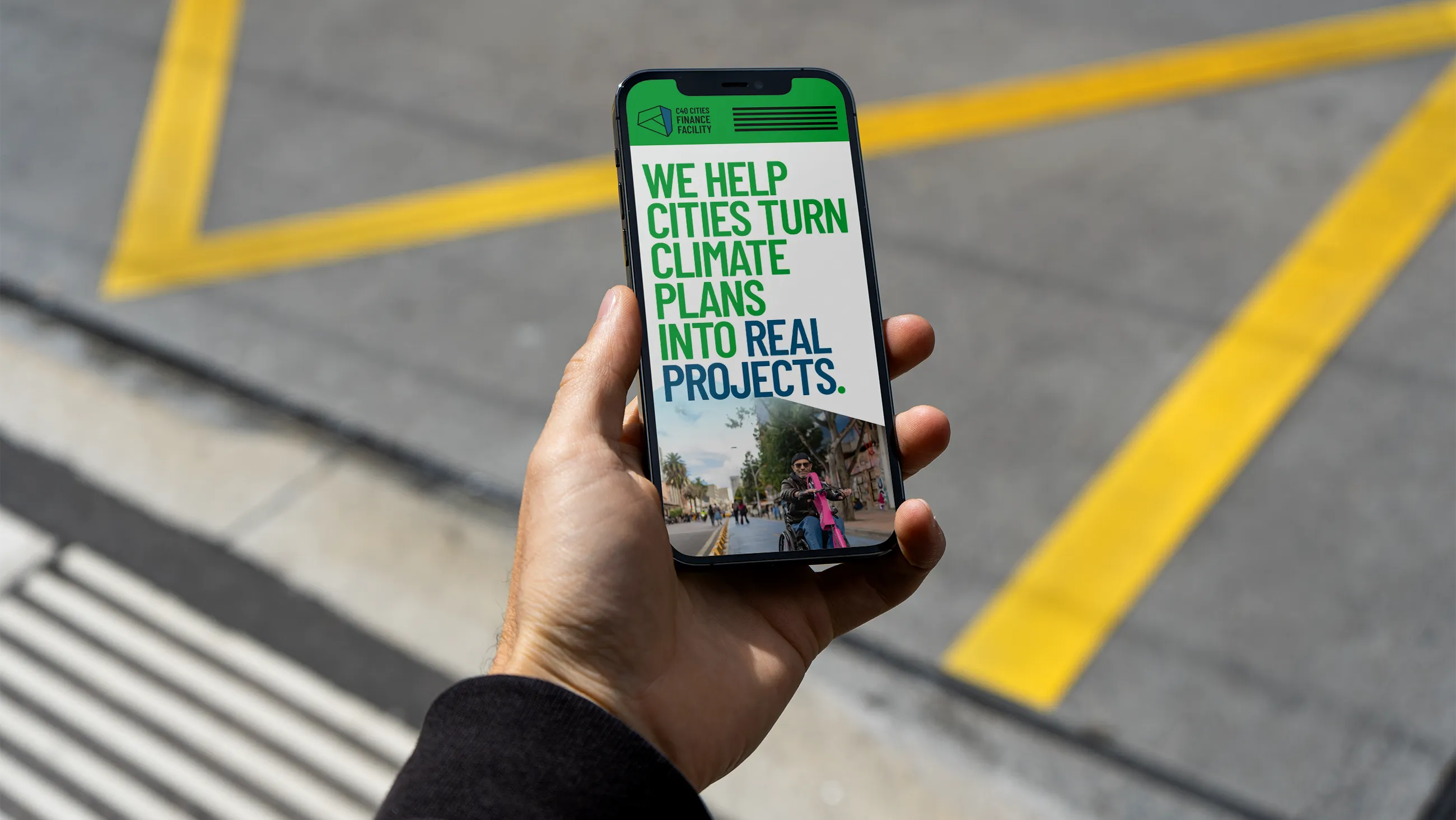 Photo of a hand holding a phone with a web page on it.