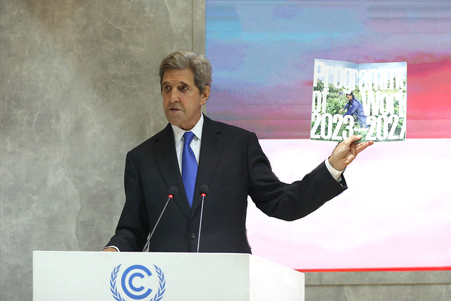 Photo of John Kerry holding a booklet.