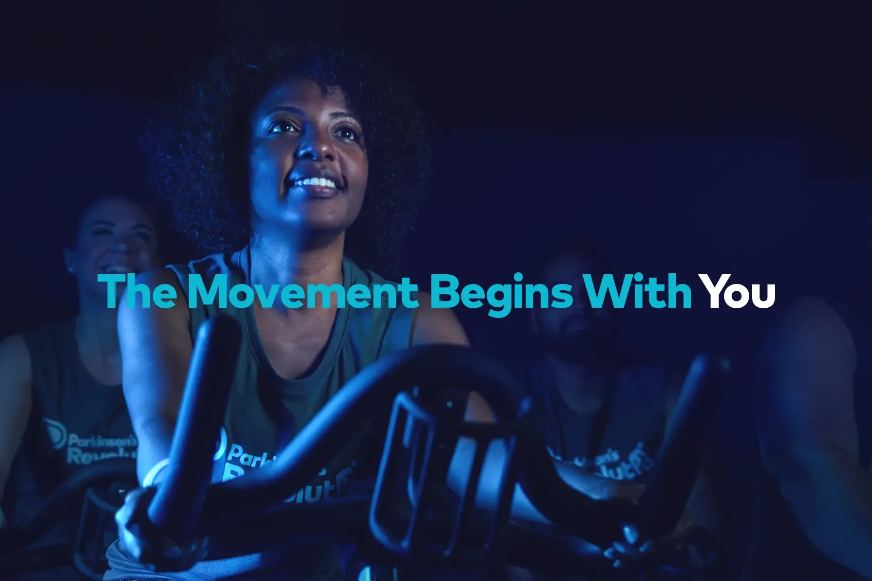 Woman on an exercise bike for Parkinson's Revolution case study with the tagline The Movement Begins With You.