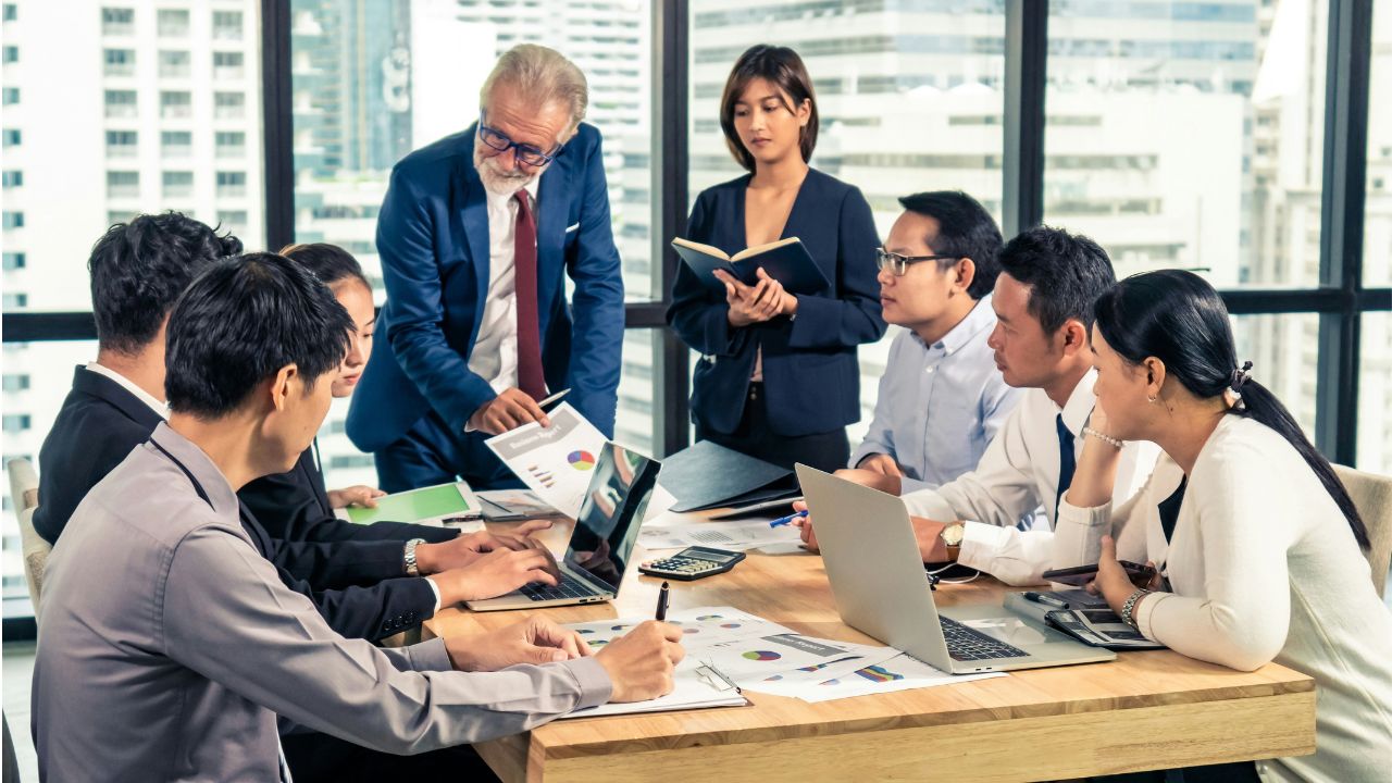 An executive sketching a presentation structure on a whiteboard — how to structure a board-level message.