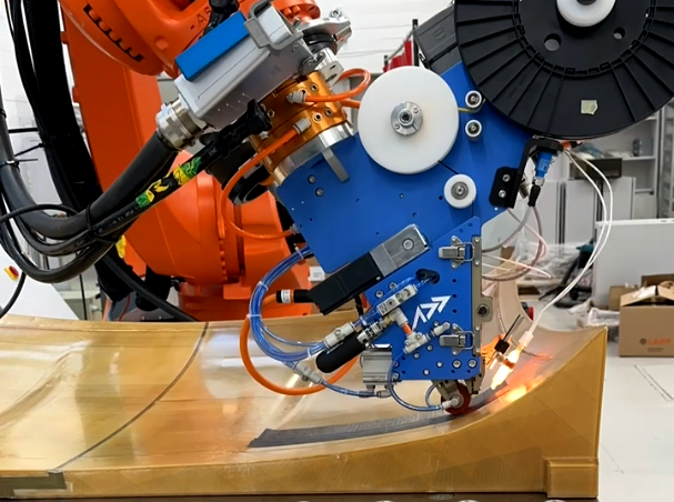 Addcomposites AFP-XS head unit depositing tow over a curved surface