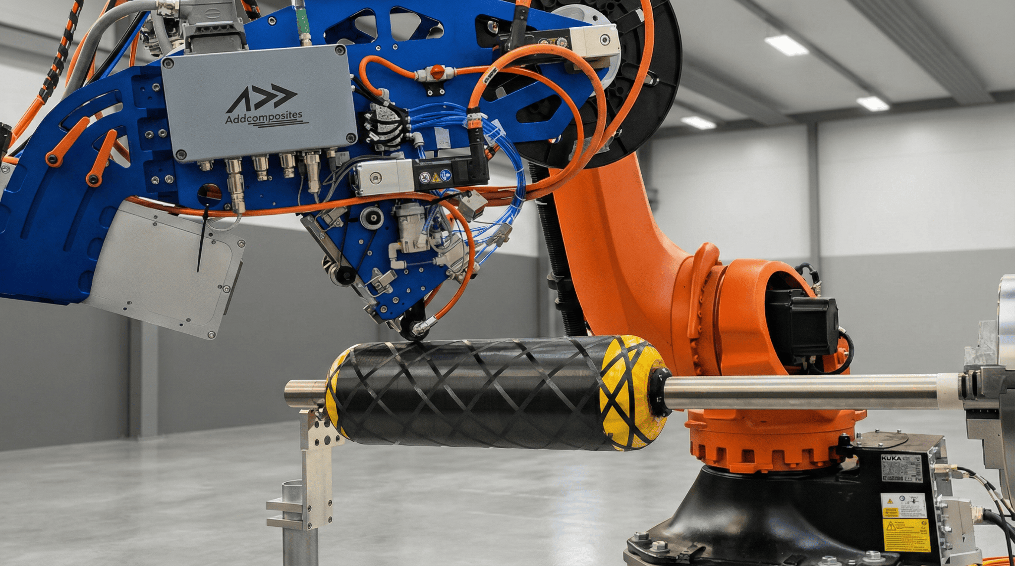 AFP-XS automated fiber placement system on cylindrical composite mandrel