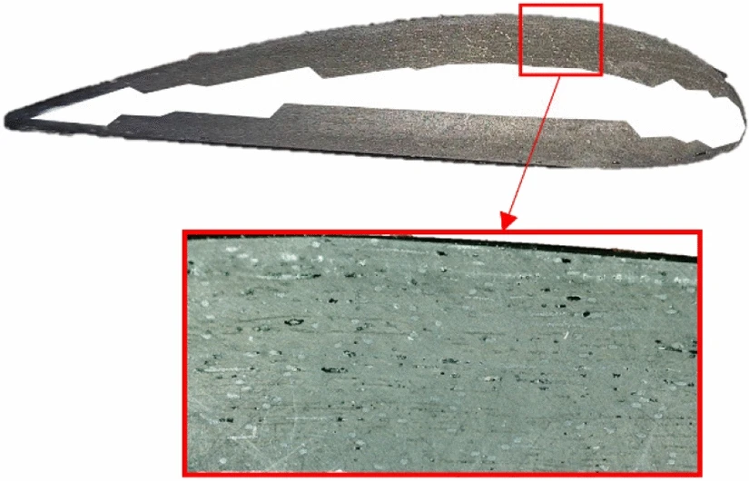 A section cut through a propeller made from Unidry 80 g/m², with a magnified view of the laminate showing black porosity voids.
