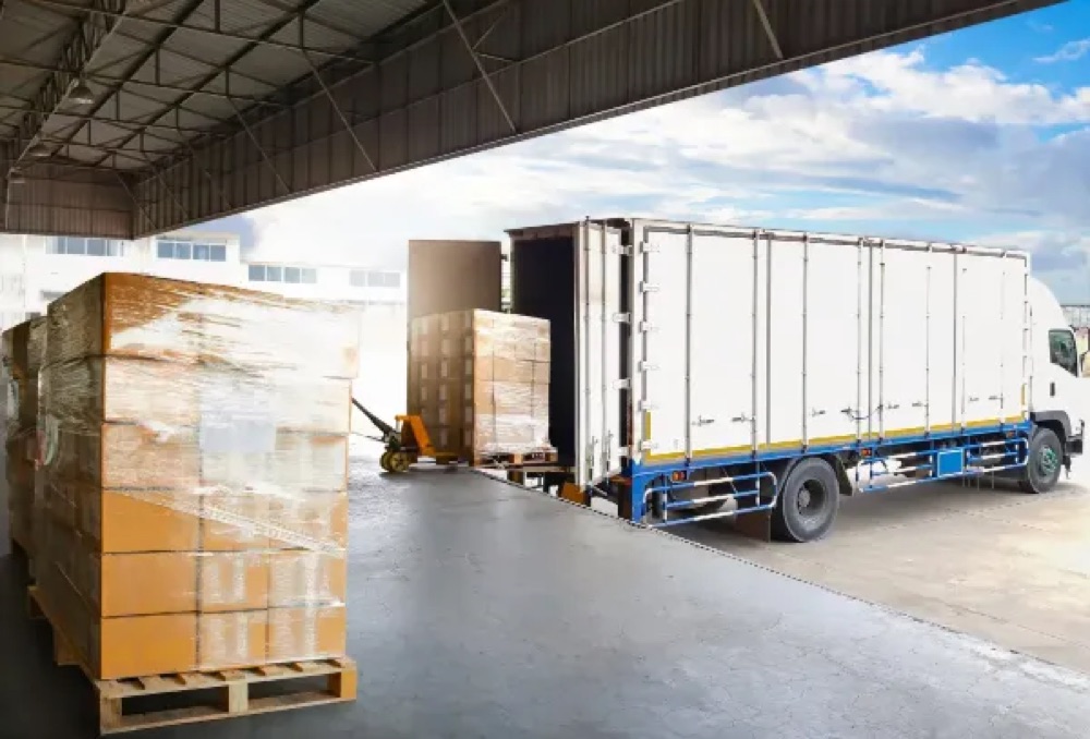 Pallets being loaded onto a delivery lorry at a warehouse dock, representing real-time loading visibility