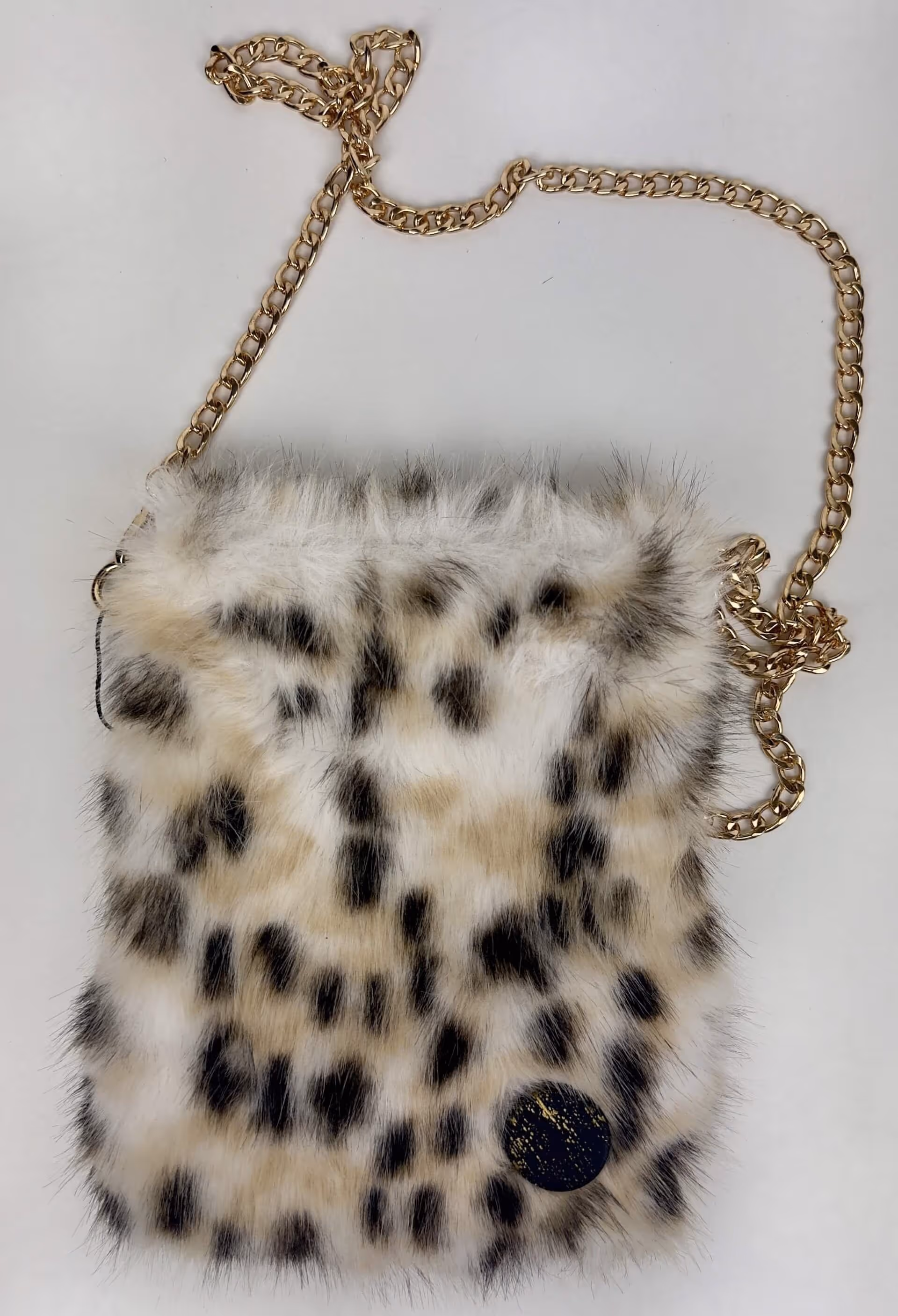 Borsa pelliccia ecologica maculata con una spilla con un'opera dipinta che la rende ancora più unica.