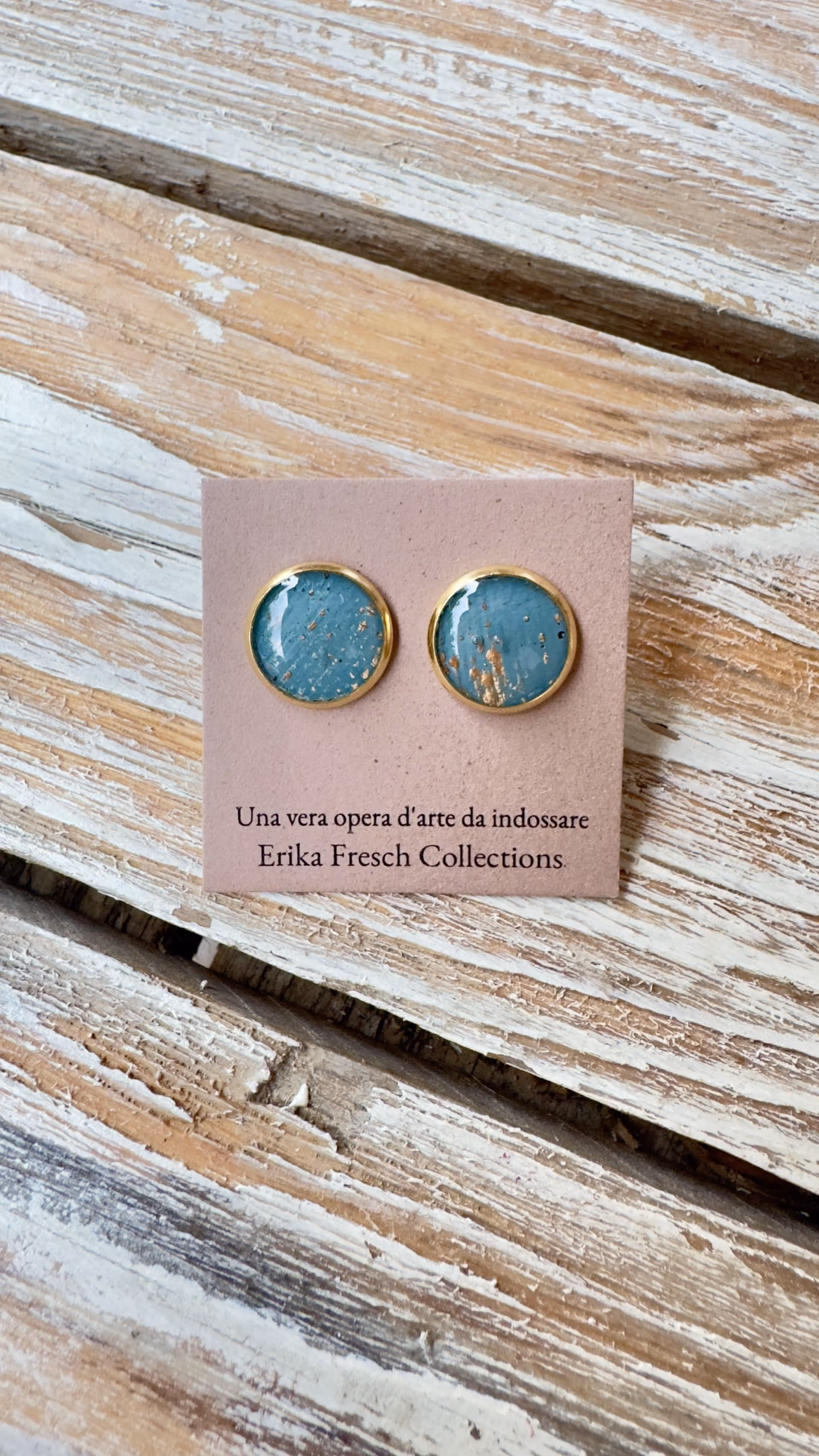 Orecchini a Bottone color ottanio e oro che includono una tela dipinta che rappresentano l'eleganza.