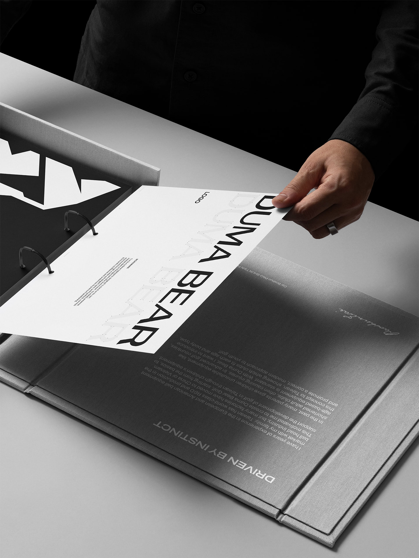 Duma Bear brand book on a white table with a man turning the pages.