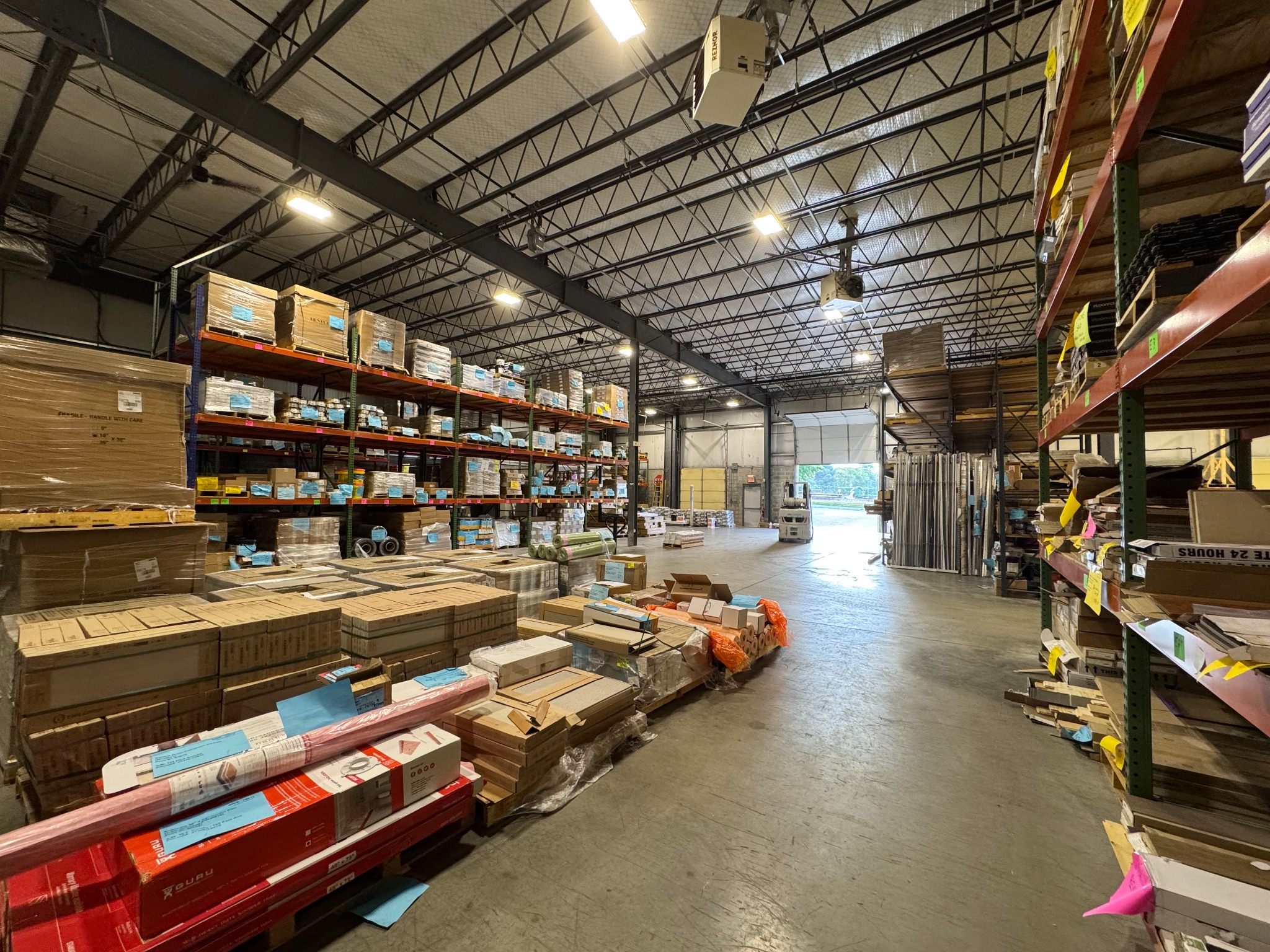 Flooring materials organized on warehouse racks and pallets at Pro-Tech Floors