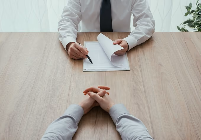 Two men sitting at a table, one interviewing another