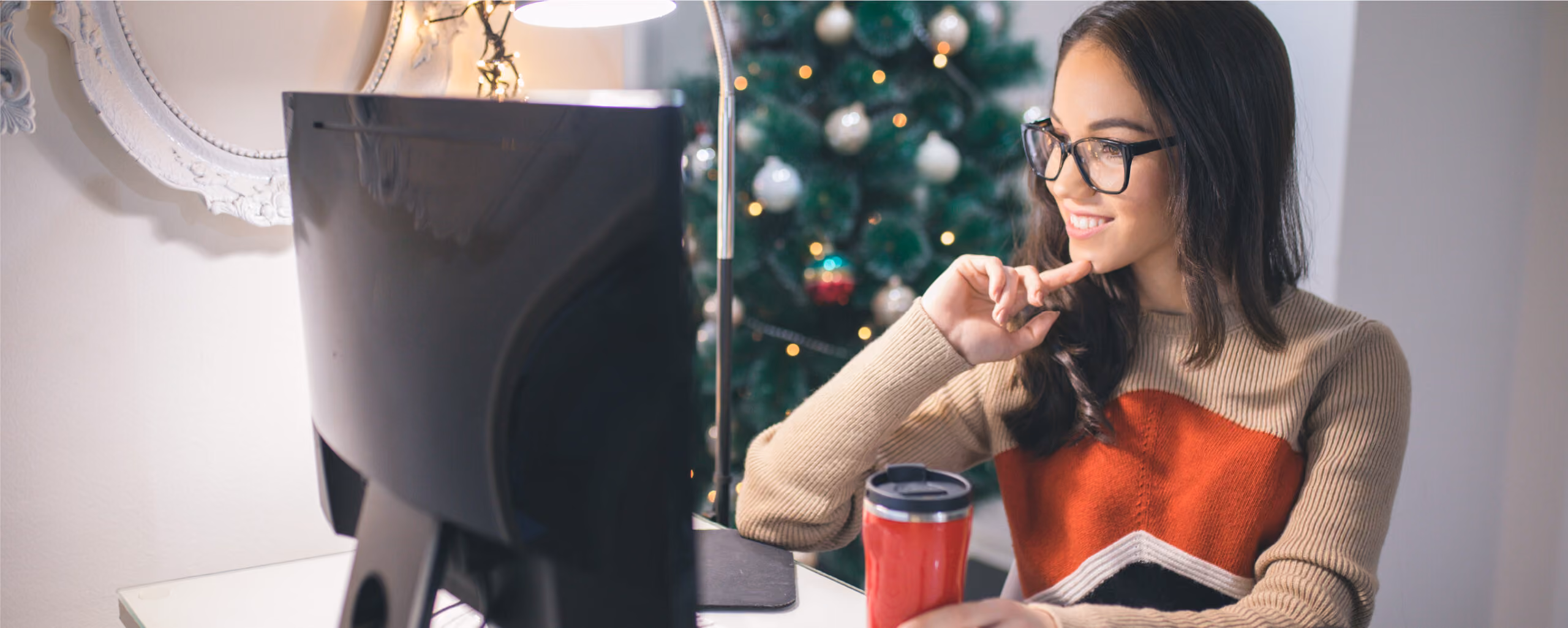 woman working on a desktop with a Christmas tree in the background|download festive social media icons|download festive website banners|download festive website buttons|festive banner mock ups|festive button mock ups|social media icon sets||festive font examples|ways to make a festive website|festive button examples|festive logo example|festive image examples|festive social media icons|festive color palettes|festive website examples||festive image examples
