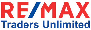 RE/MAX Traders Unlimited real estate logo with red and blue text.