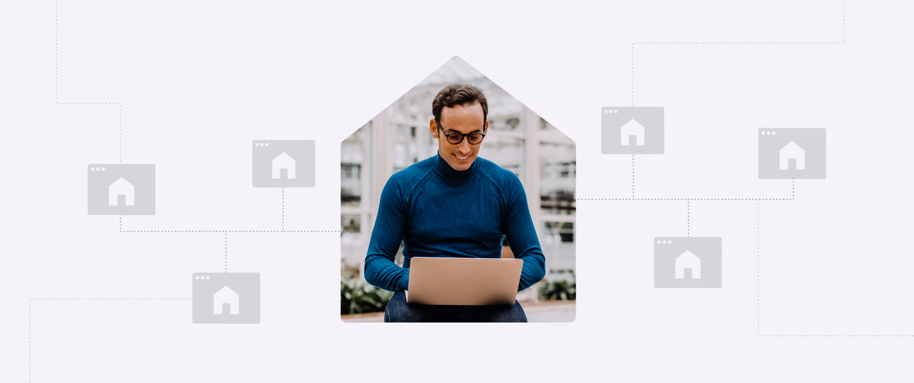 Man in glasses and blue sweater sitting with a laptop inside a house-shaped frame.