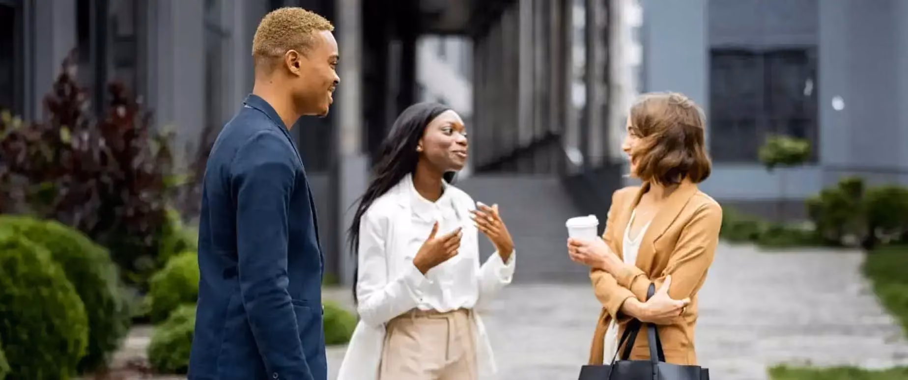 A female real estate agent meets with and talks to potential clients in front of an open house