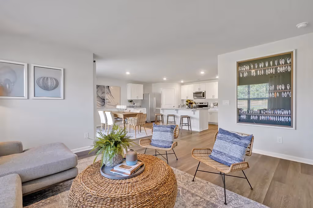 Open concept living area at Landing at Stone Chimney, Supply NC, connecting the living room, dining area, and modern white kitchen with an island