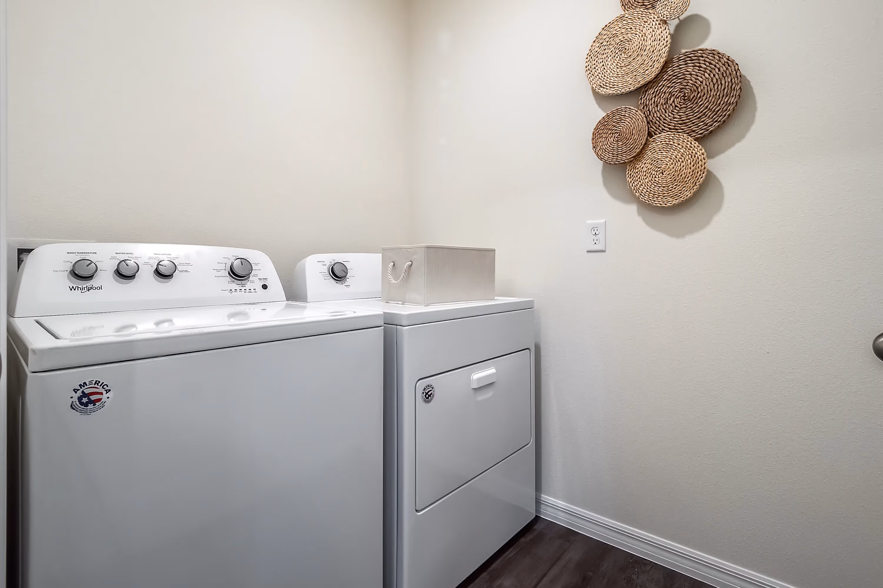 Laundry area in a Landing at Stone Chimney home, Supply NC, with a white Whirlpool washer and dryer, and decorative wall art