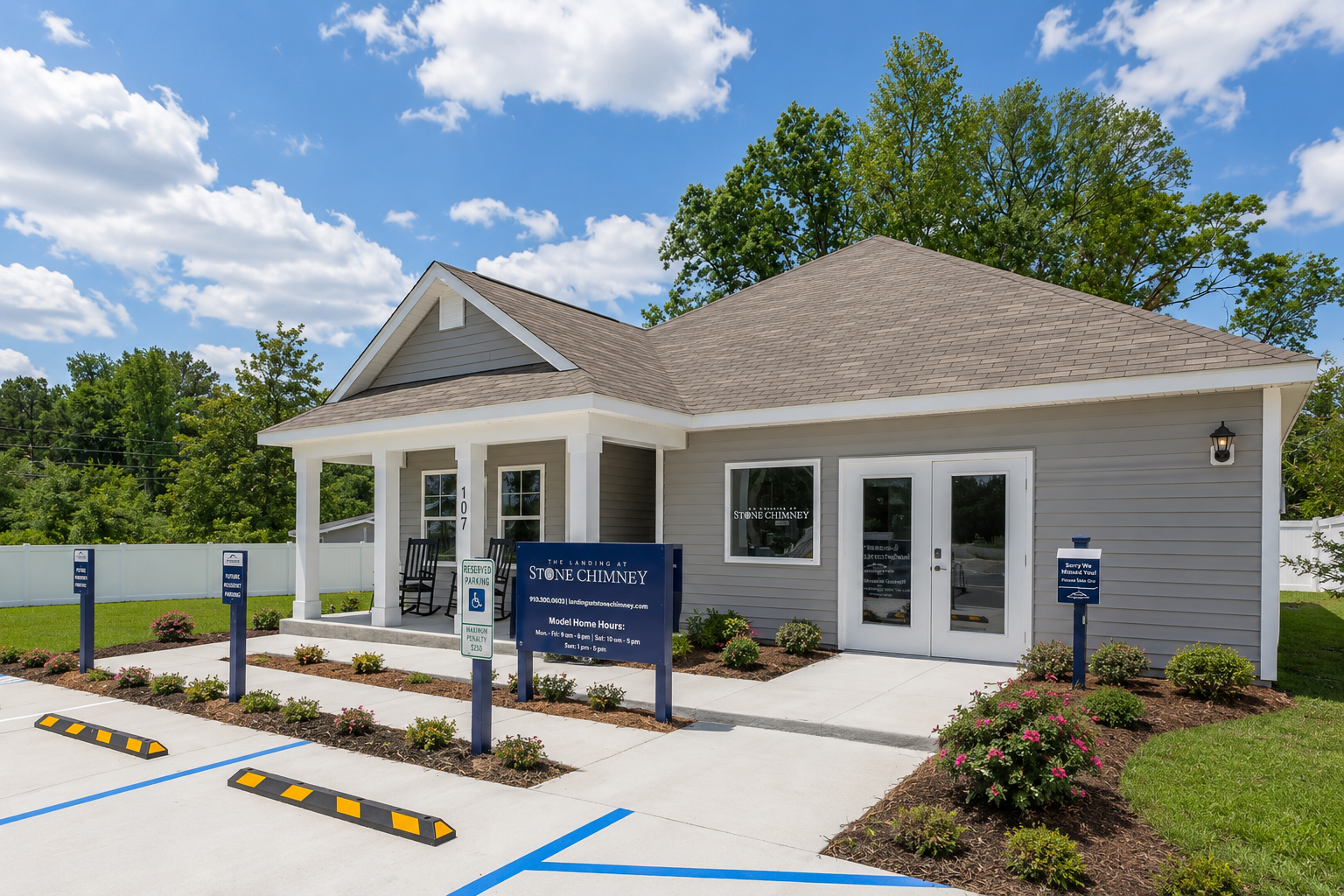 Exterior of the Landing at Stone Chimney community clubhouse or sales office in Supply, NC, with light gray siding, white pillars, and prominent signage