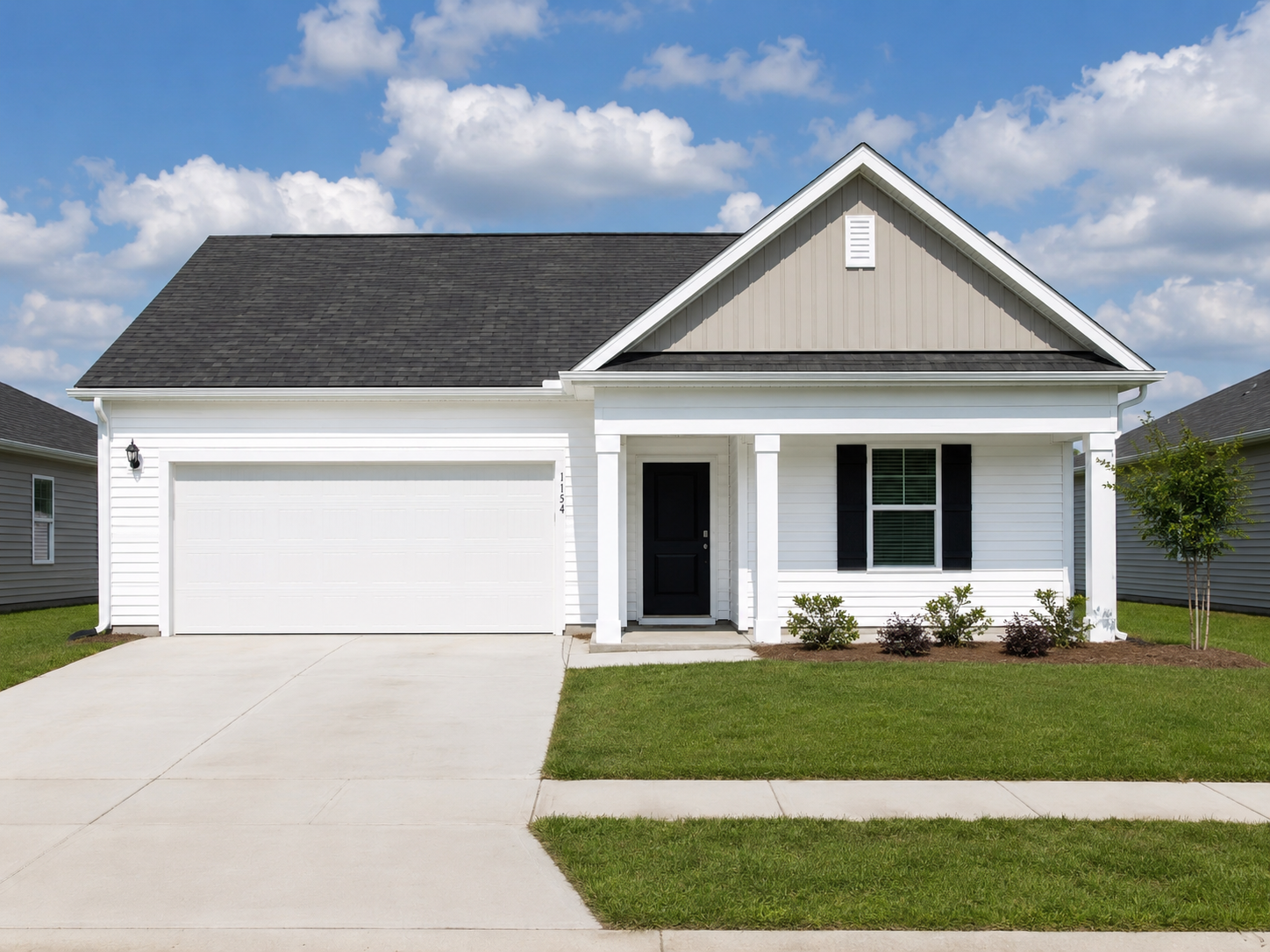Brand new white single-story home at Landing at Stone Chimney, Supply NC, with a blue and white gable, black front door, and white garage door