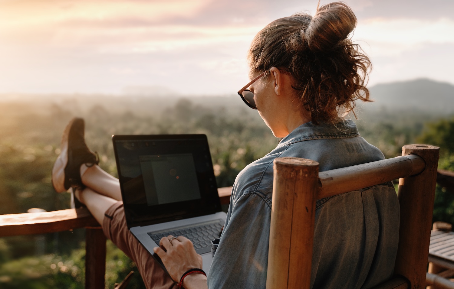 working remote on a rustic balcony overlooking jungle canopy