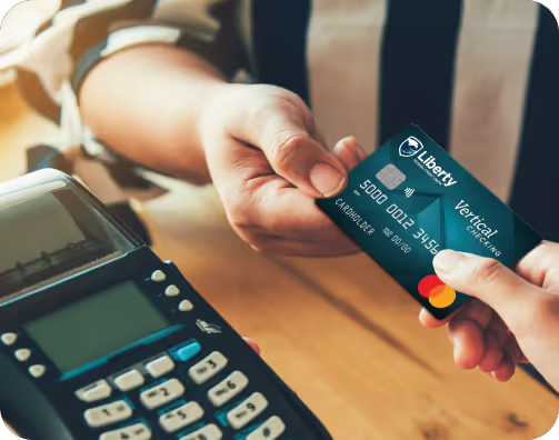 A person is holding a blue and white Liberty FCU card.