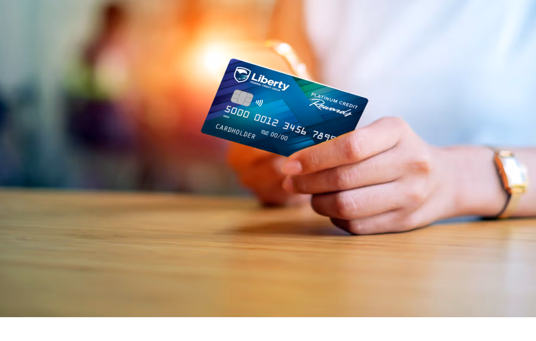 A person holding a Liberty FCU credit card.