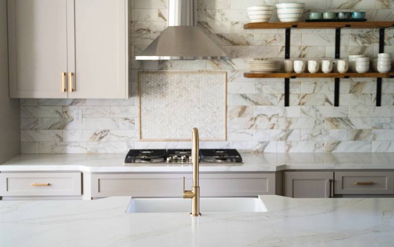 Kitchen with white marble countertops and backsplash.