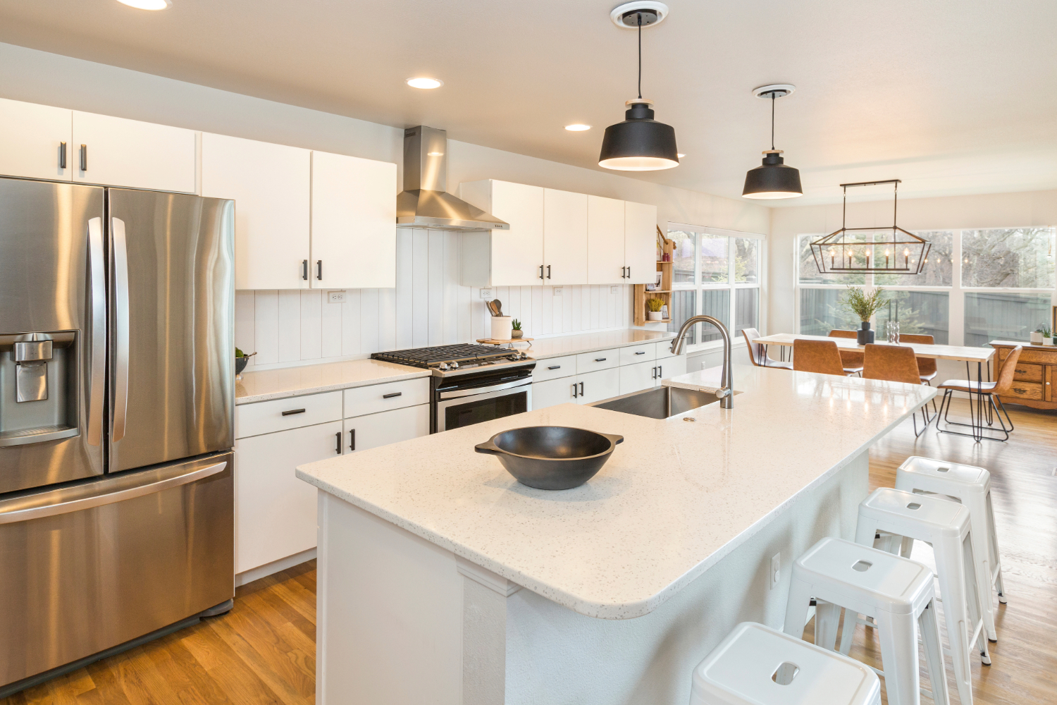Modern kitchen with white quartz countertops and black accents.