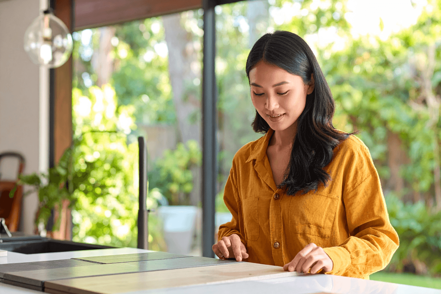 Eco-conscious homeowner at kitchen island reviewing countertop slabs