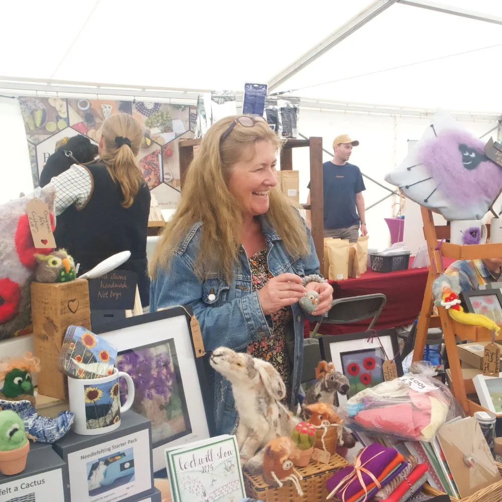 Lady smiling and chatting at an indoor show trade stand