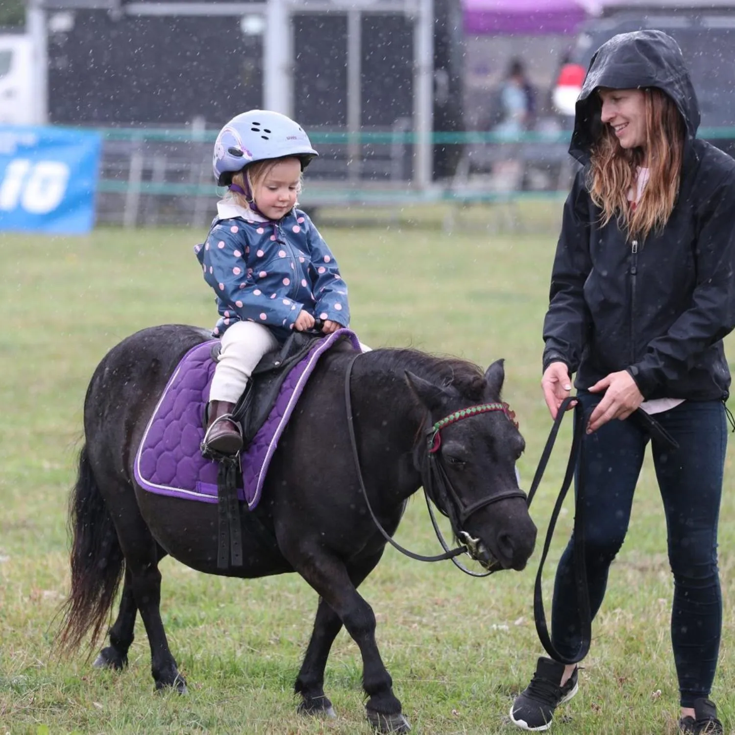 Young girl on a pony led by her monther.