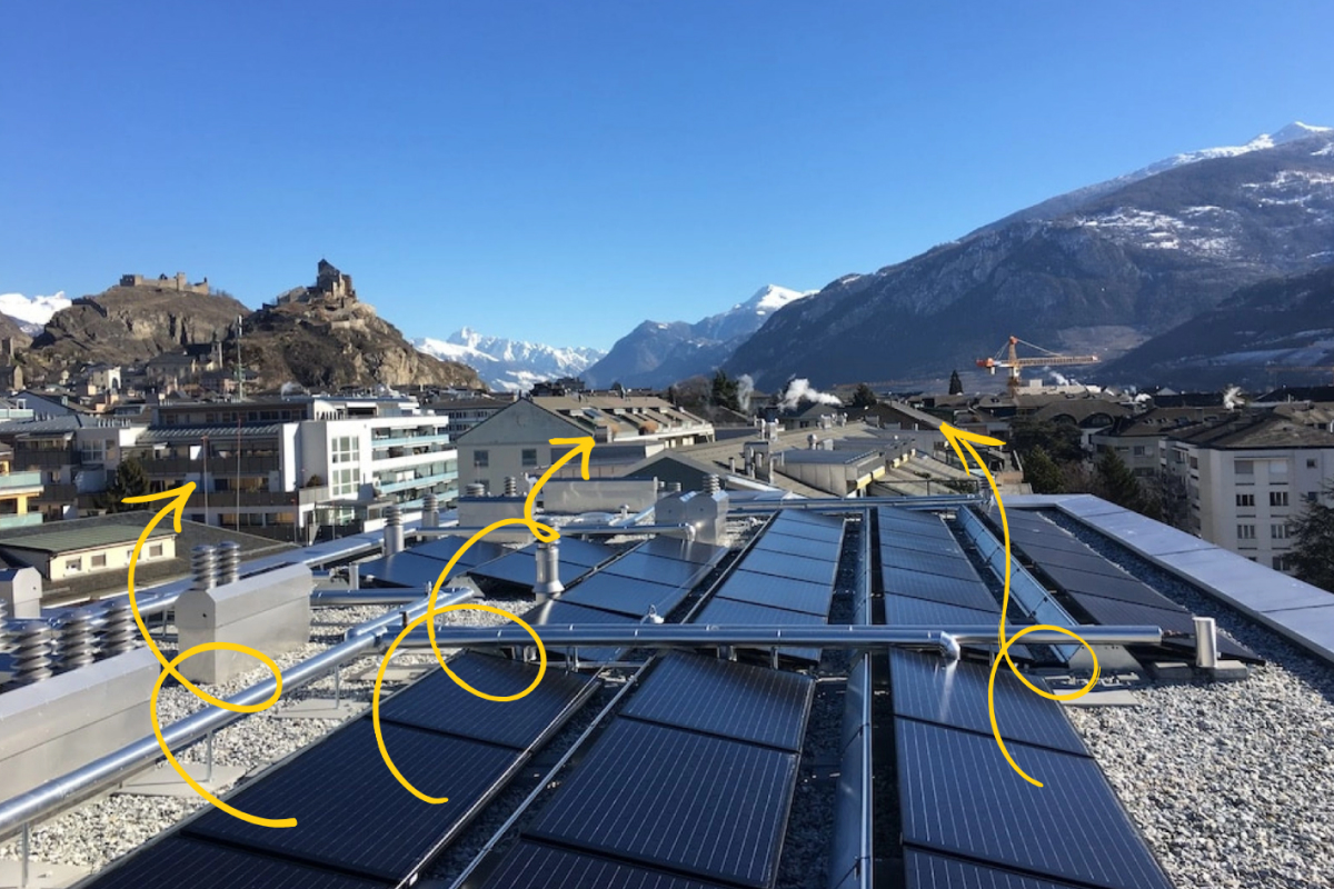 Solarpanels auf einem Dach mit Bergen im Hintergrund.