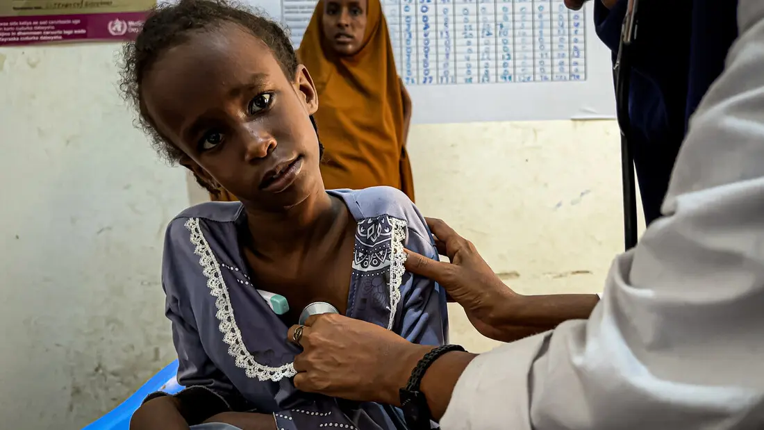 Ein medizinisches Personal misst die Temperatur eines Mädchens in einer Gesundheitseinrichtung in Zentralsomalia.