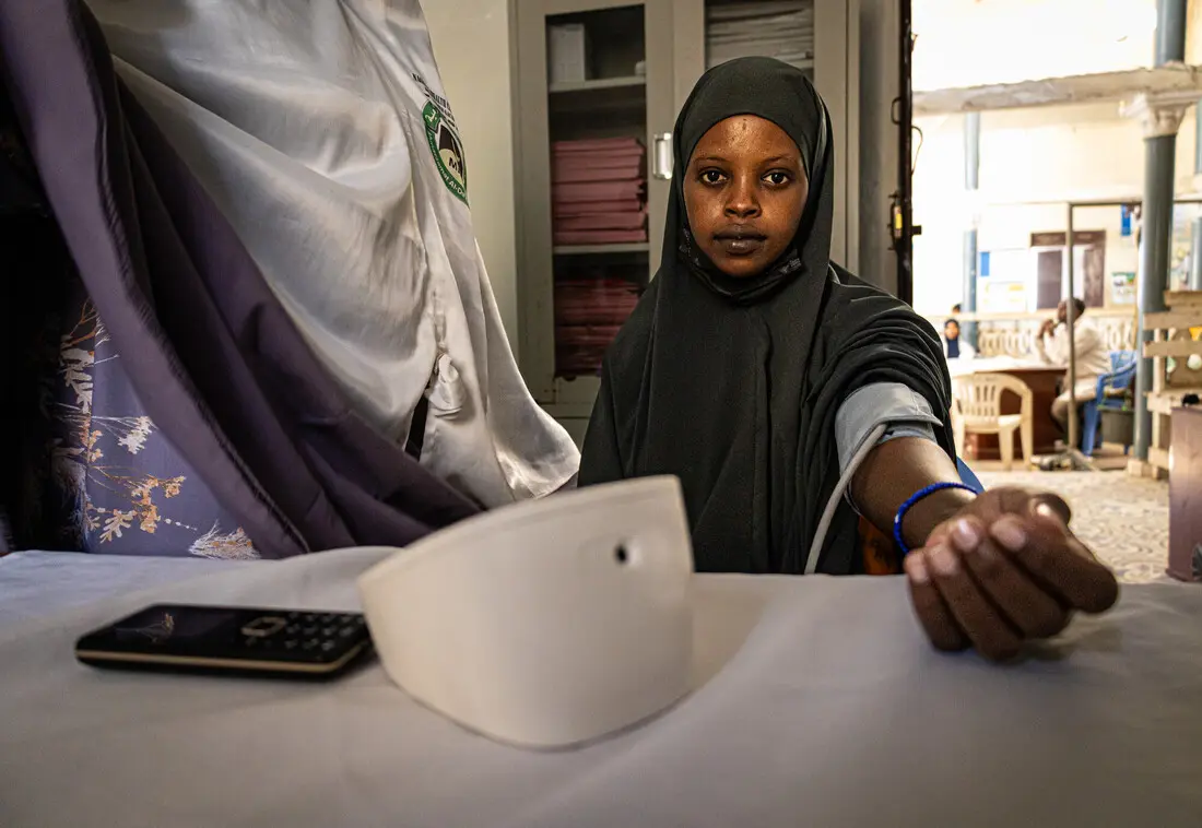 Ein Gesundheitshelfer misst den Blutdruck einer Frau in einer Gesundheitseinrichtung in Zentralsomalia.