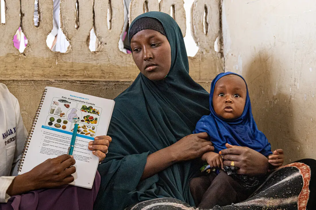 A mother holding her child during Infant and Young Child Feeding (IYCF) training in a health facility in central Somalia.