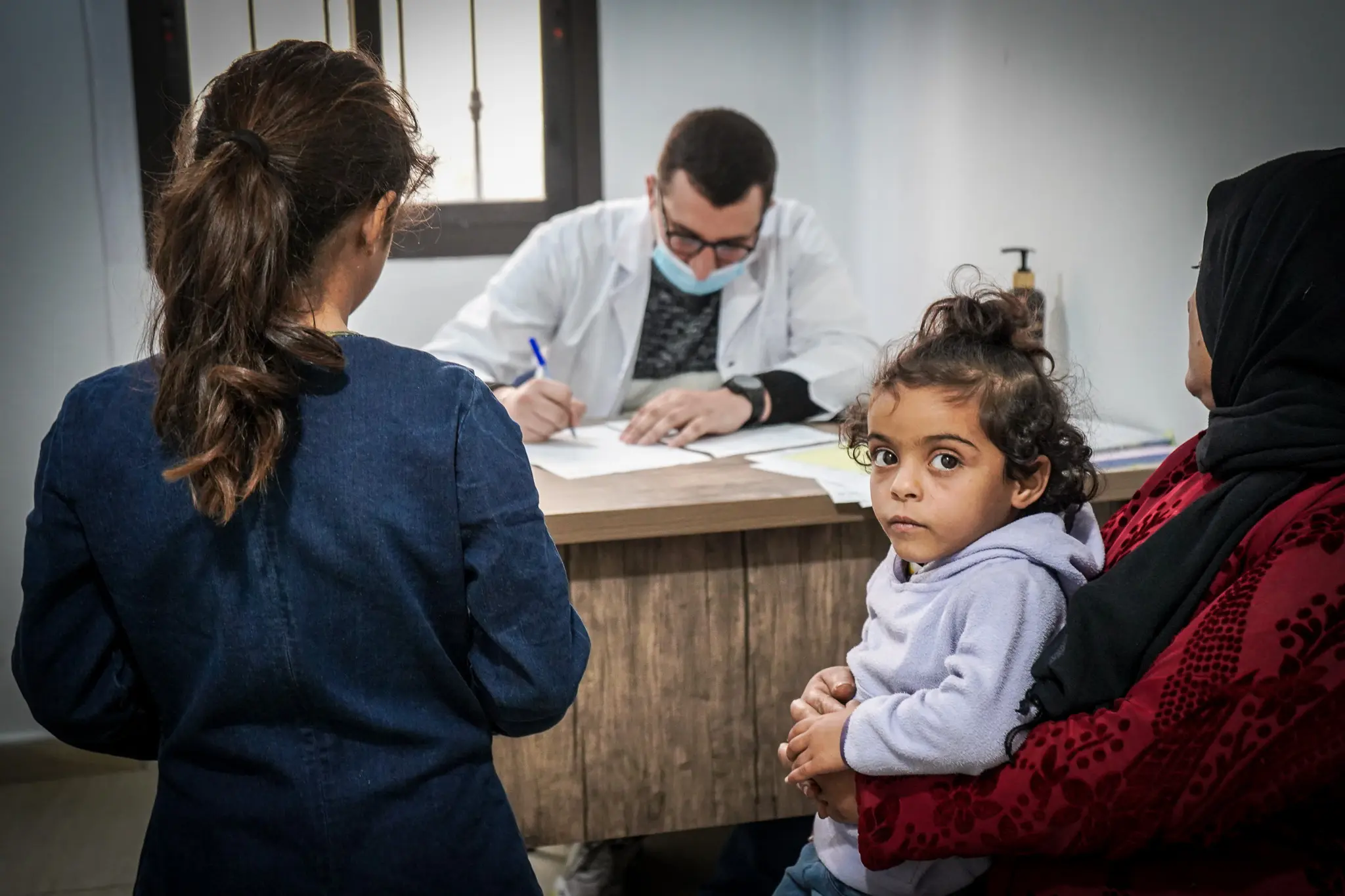 A Syrian refugee mother and her daughter receive a doctors consultation at a primary healthcare centre. 