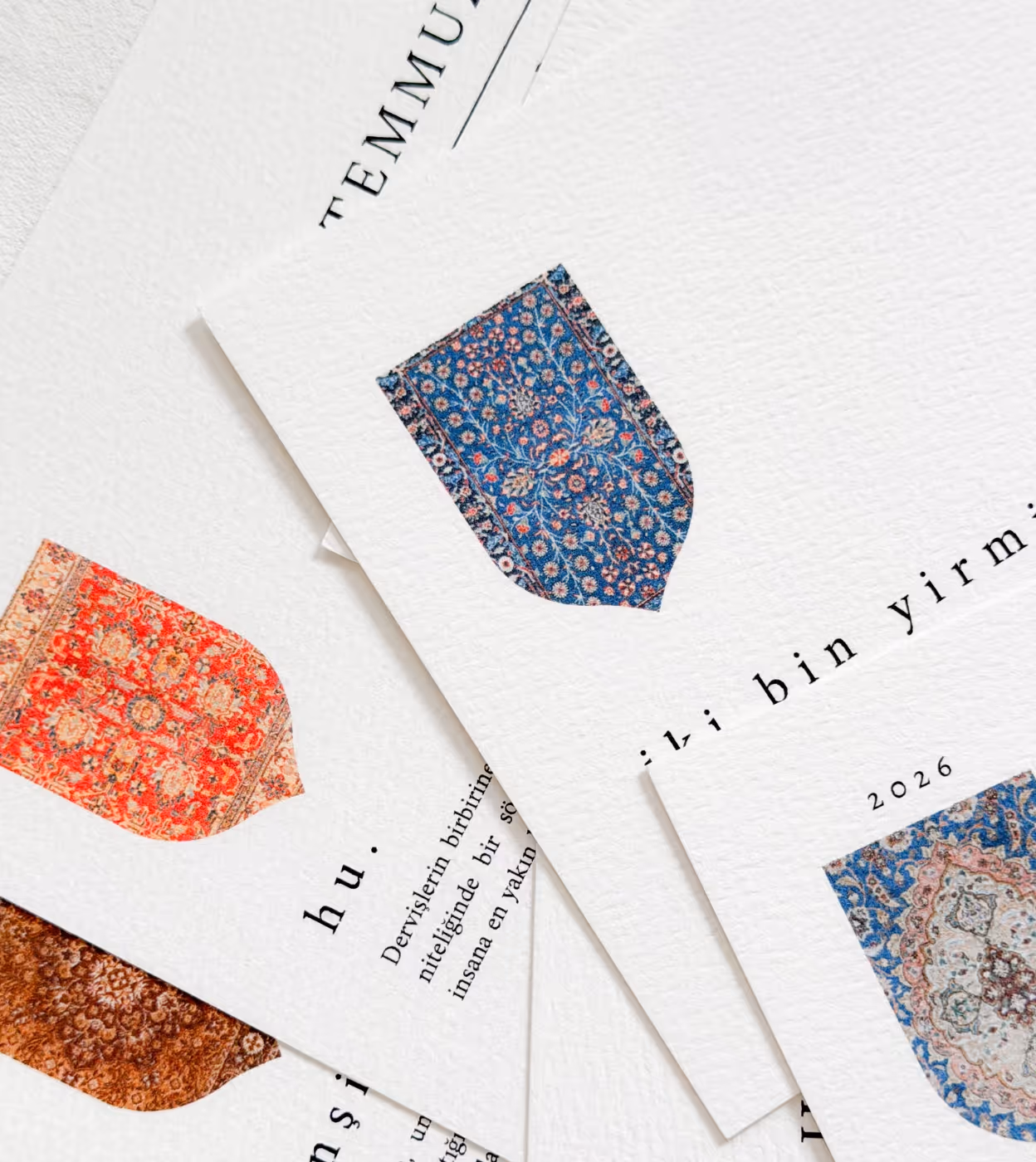Mehrere übereinander liegende Papierkarten mit Fotos von dekorativen Teppichen und türkischem Text.