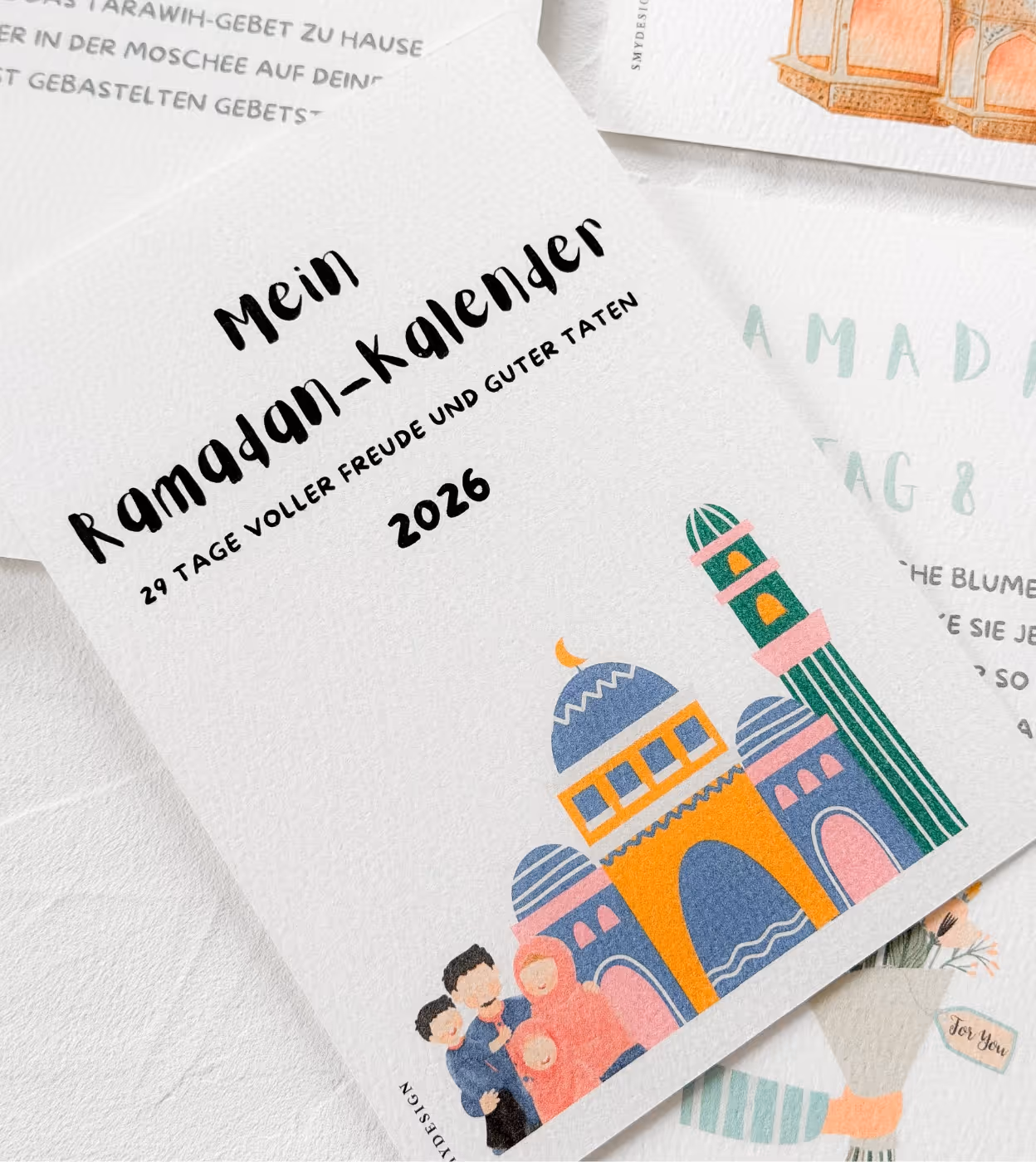 Deckblatt eines Ramadan-Kalenders 2026 mit der Aufschrift 'Mein Ramadan-Kalender, 29 Tage voller Freude und guter Taten' und einer Illustration einer Familie vor einer bunten Moschee.