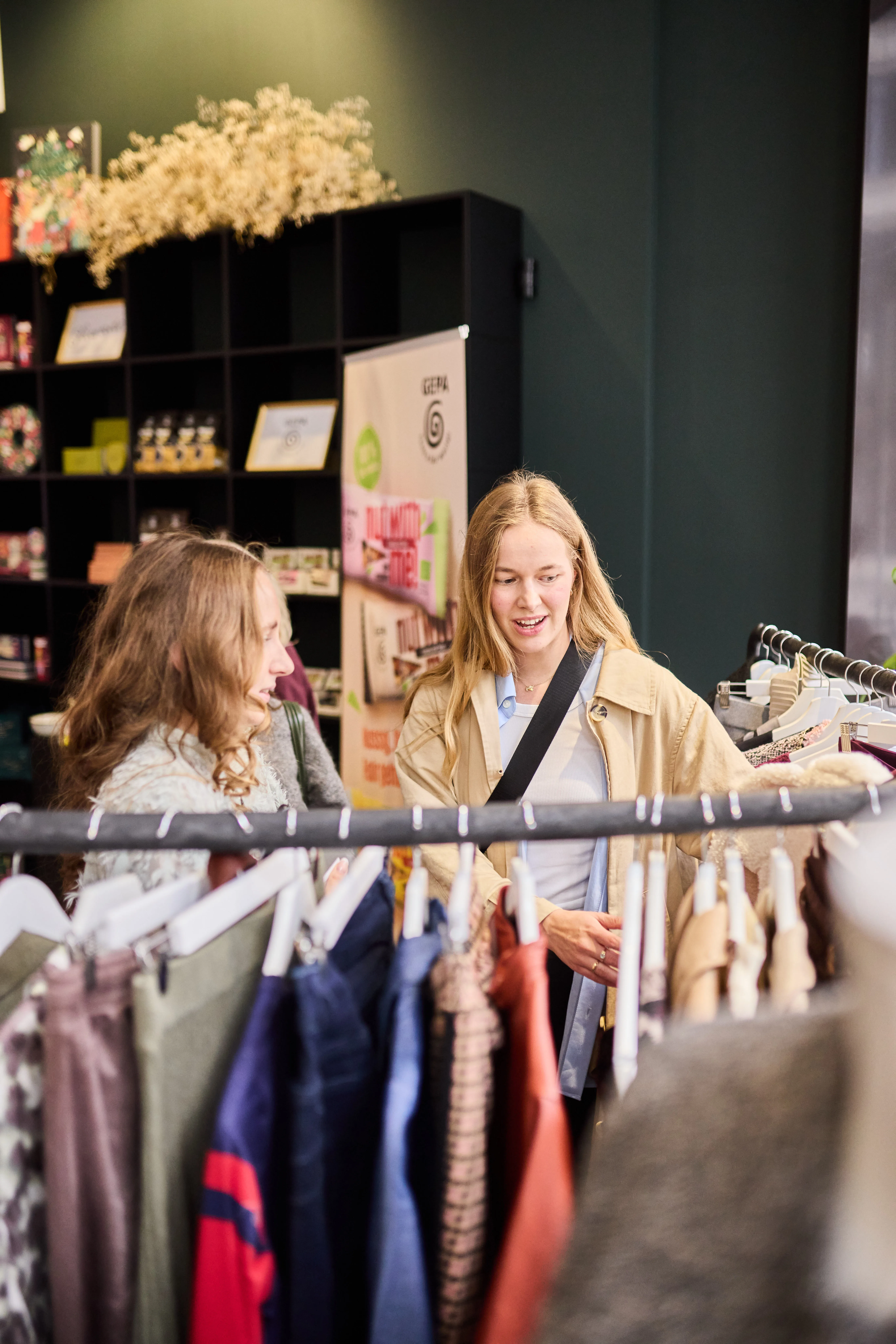 Zwei Frauen sehen sich Kleidung an einem Kleiderständer im Showroom an