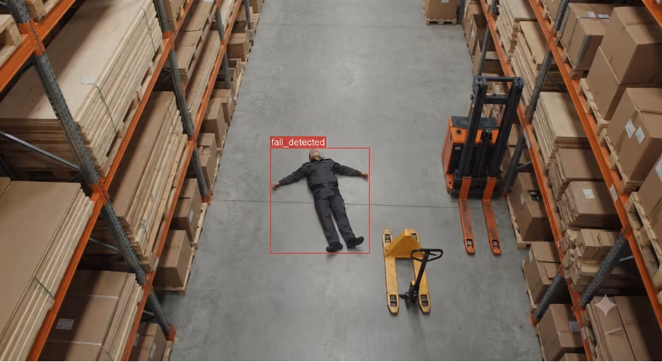 AI vision system detecting a fallen worker on a warehouse floor and triggering a fall alert.