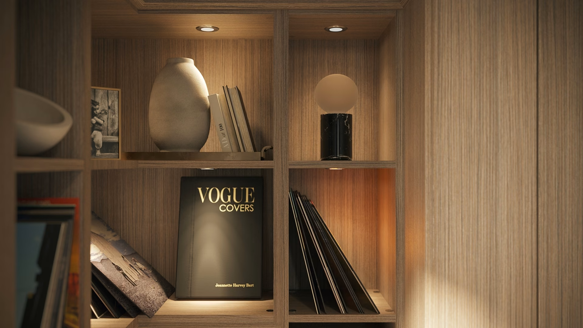 Open home office shelving holding books and a few decorative objects under warm light.