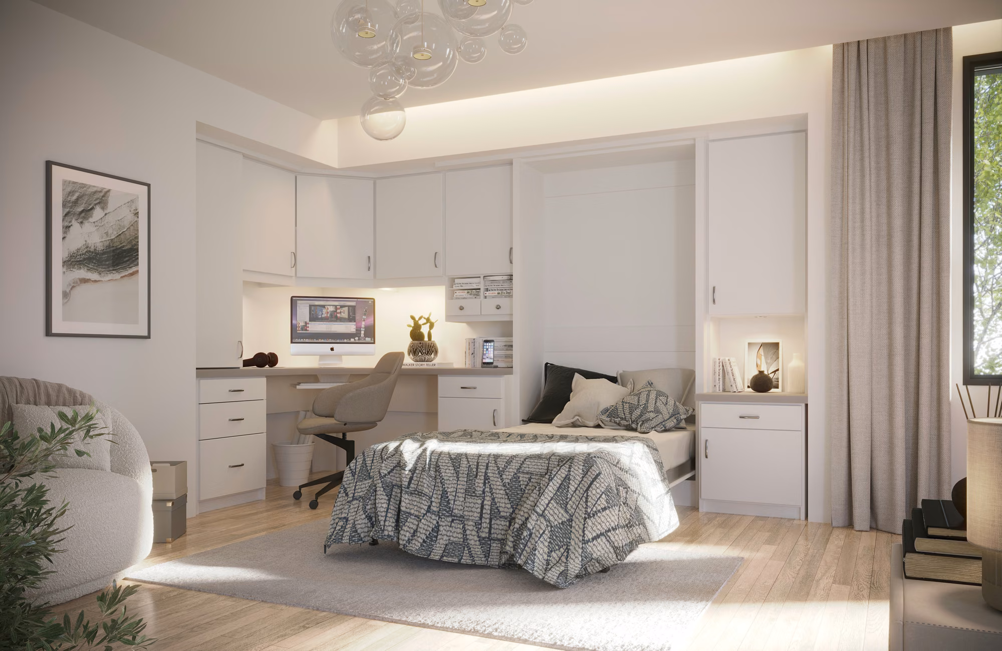Murphy bed lowered and made up beside a built-in desk with a monitor, in a white wall unit with overhead cabinets.