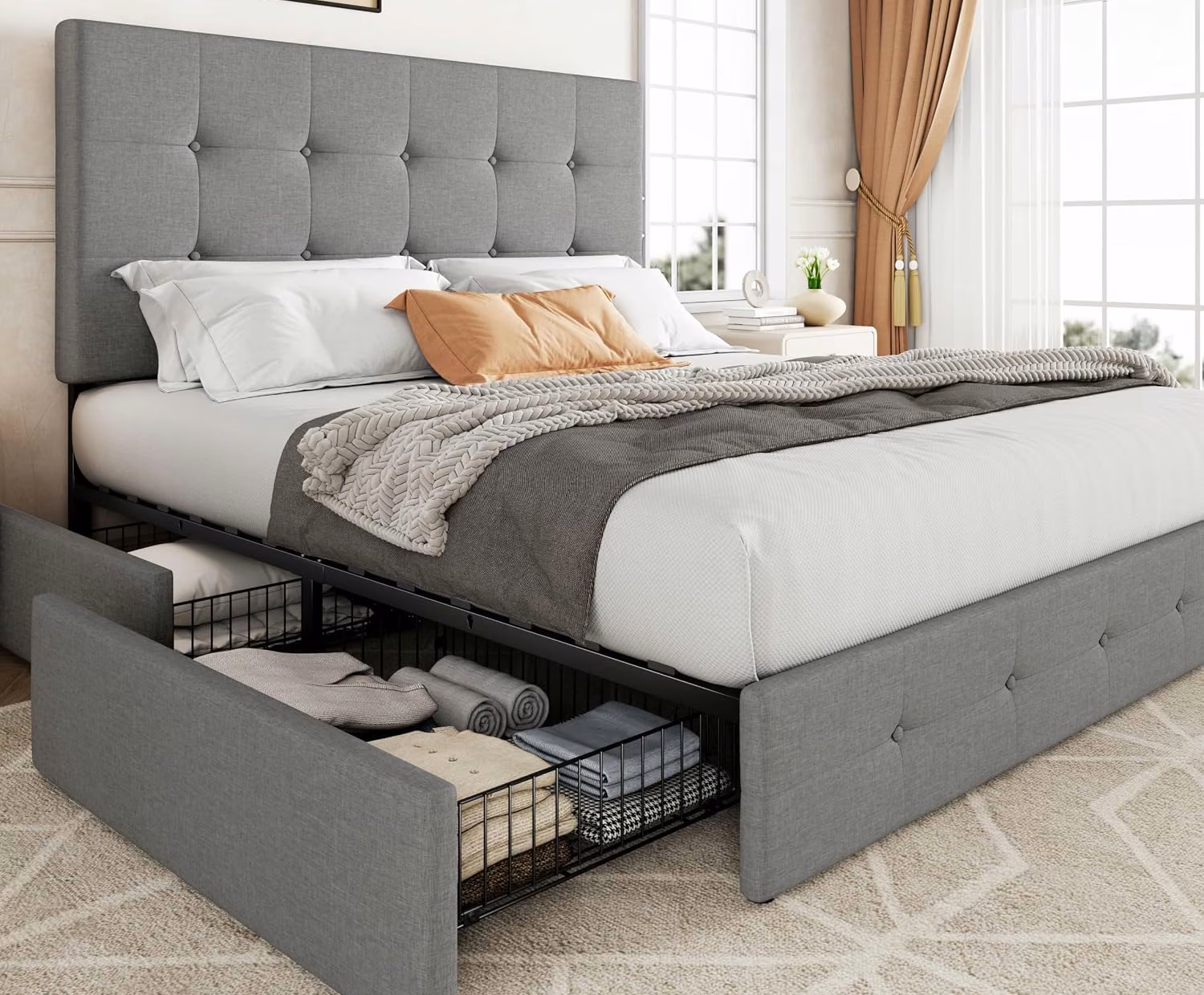 Upholstered platform bed with a pull-out under-bed storage drawer holding folded linens.